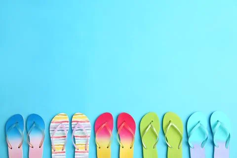 Different flip flops and space for text on blue background, flat lay. Summer  Stock-Fotos