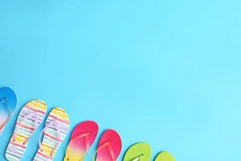 Different flip flops and space for text on blue background, flat lay. Summer  Stock-Fotos