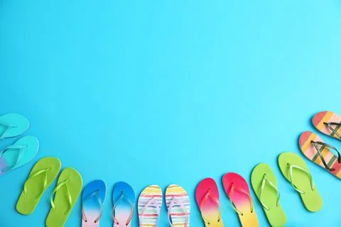 Different flip flops and space for text on blue background, flat lay. Summer  Stock-Fotos