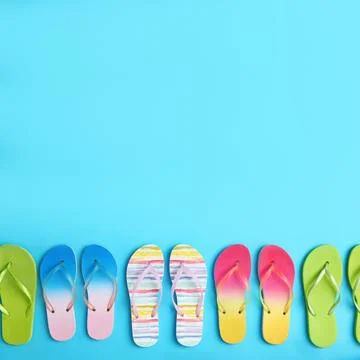 Different flip flops and space for text on blue background, flat lay. Summer  Stock-Fotos