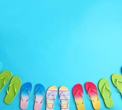 Different flip flops and space for text on blue background, flat lay. Summer  Stock Photos