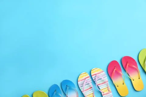 Different flip flops and space for text on blue background, flat lay. Summer  Stock Photos