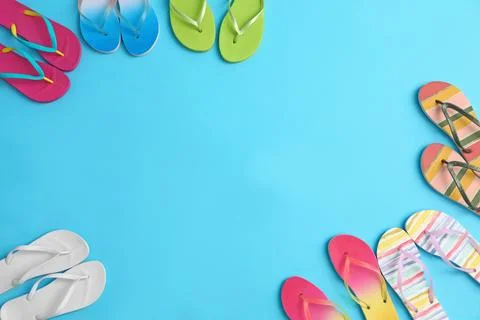 Different flip flops and space for text on blue background, flat lay. Summer  Foto stock