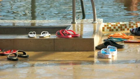 Different flip flops by the outdoor swimming pool. Stock Footage 116792299