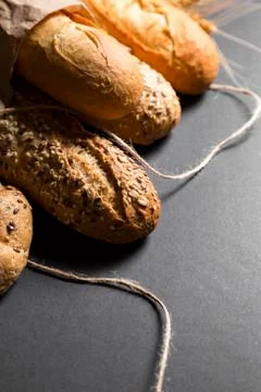 Different fresh bread with seeds, on black background Stock Photos