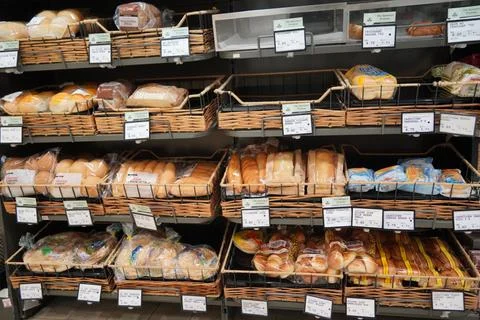 Different fresh bread on the shelves in bakery. Interior of a modern grocery Stock-Fotos