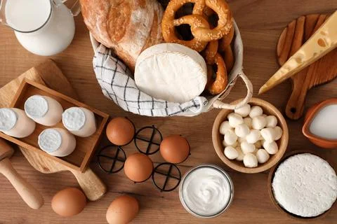 Different fresh dairy products with bread on table in kitchen, top view Stock Photos