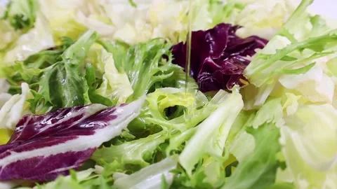 Different fresh lettuce cut salad leaves rotation with pouring olive oil Stock Footage 232155286