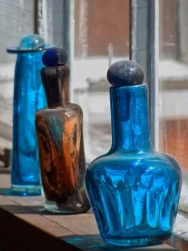 Different glass flasks on a windowsill Stock Photos