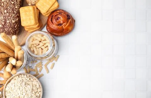 Different gluten free products on white tiled table, flat lay. Space for text Stock Photos