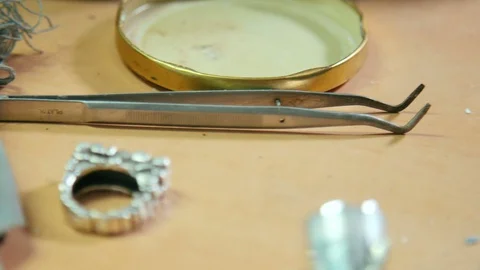 Different goldsmiths professional tools and silver ring inside jewelry worksh Stock Footage 128463981