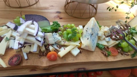 Different grade sliced cheese, bunches of grapes and lettuce lies on table. Stock Footage 199033806
