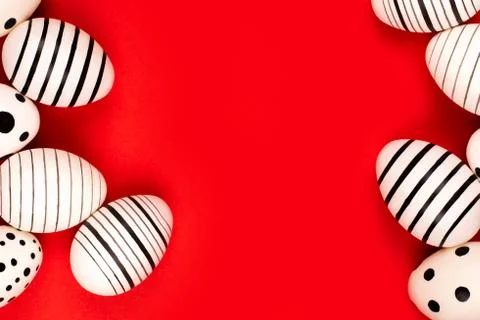 Different graphic hand-painted eggs on bright red background. Stock Photos