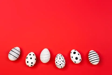 Different graphic hand-painted eggs on trendy coral background. Stock Photos