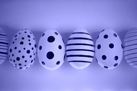 Different graphic hand-painted eggs in Proton Purple neon light. Stock Photos