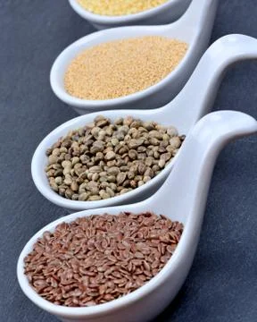 Different groats in a ceramic spoons Stock Photos