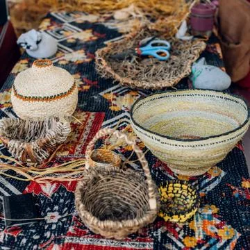 Different hand made weave basckets on table. Craft workshop. Close up shot Stock Photos
