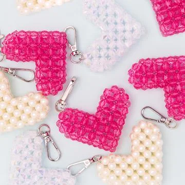 Different handcraft keychains in a heart shape made from acrylic beads. Stock Photos