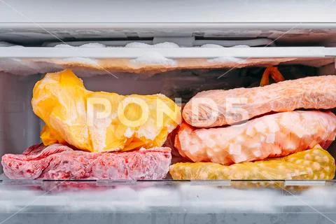 Different kind of deep frozen vegetables in plastic bags in a refrigerator Stock Photos