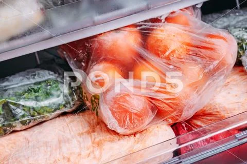 Different kind of deep frozen vegetables in plastic bags in a refrigerator Stock Photos