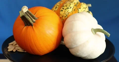Different kind of pumpkins with seeds rotating on plate 스톡 동영상 141341908
