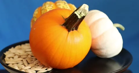 Different kind of pumpkins with seeds rotating on plate Stock Footage 141342119