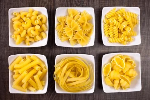 Different kind of raw pasta in small bowl Foto stock