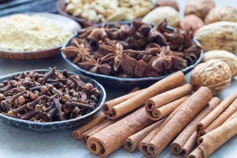 Different kinds of aromatic winter spices in bowls and on gray concrete backg Foto stock