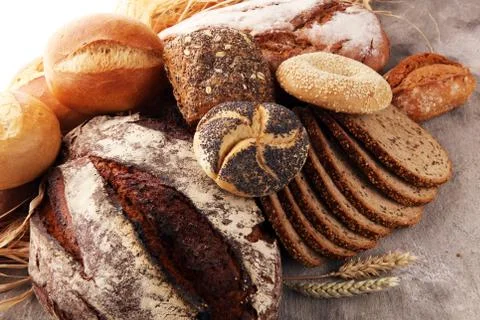 Different kinds of bread and bread rolls on board from above. Kitchen or bake Stock Photos