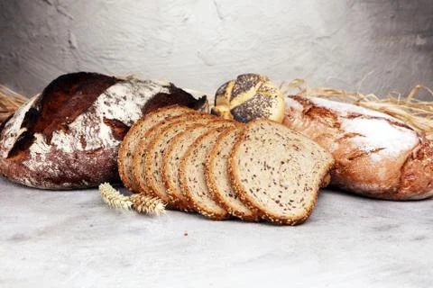Different kinds of bread and bread rolls on board from above. Kitchen or bake Stock Photos