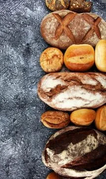 Different kinds of bread and bread rolls on board from above. Kitchen or bake Stock Photos