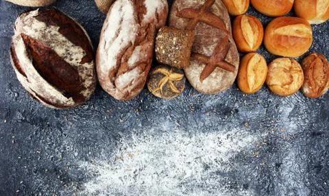 Different kinds of bread and bread rolls on board from above. Kitchen or bake Stock Photos