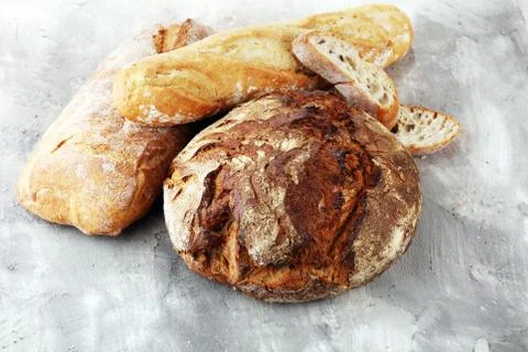 Different kinds of bread and bread rolls on board from above. Kitchen or bake Stock Photos
