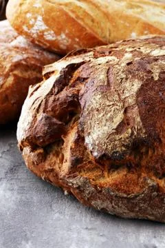 Different kinds of bread and bread rolls on board from above. Kitchen or bake Foto stock