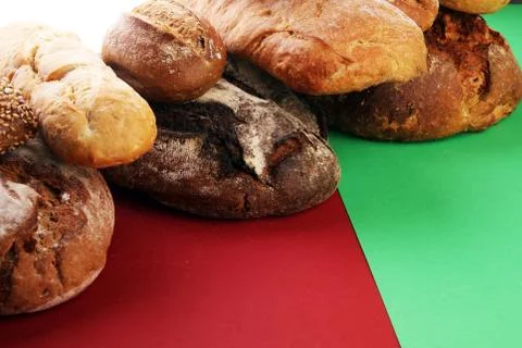 Different kinds of bread and bread rolls on board from above. Kitchen or bake Stock Photos