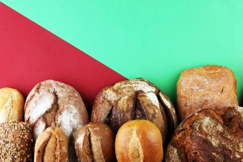 Different kinds of bread and bread rolls on board from above. Kitchen or bake Stock Photos
