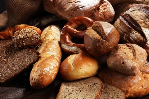 Different kinds of bread and bread rolls on board from above. Kitchen or bake Foto stock