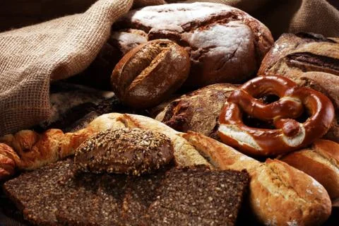 Different kinds of bread and bread rolls on board from above. Kitchen or bake Foto stock