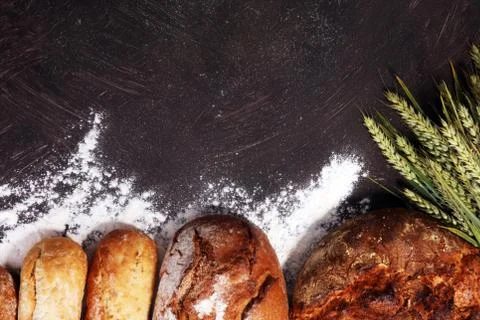 Different kinds of bread and bread rolls on board from above. Kitchen or bake Stock Photos