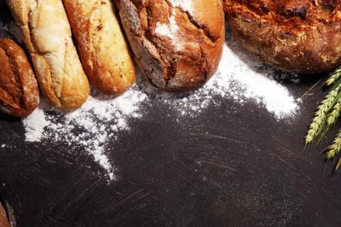 Different kinds of bread and bread rolls on board from above. Kitchen or bake Stock Photos