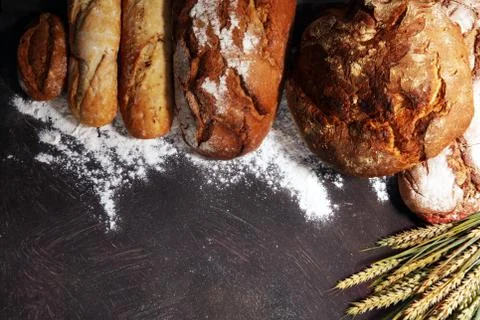 Different kinds of bread and bread rolls on board from above. Kitchen or bake Stock Photos