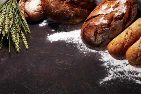 Different kinds of bread and bread rolls on board from above. Kitchen or bake Stock Photos