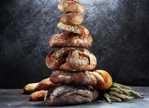 Different kinds of bread and bread rolls on board from above. Kitchen or bake Stock Photos