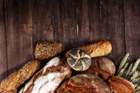Different kinds of bread and bread rolls on board from above. Kitchen or bake Stock Photos