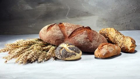 Different kinds of bread and bread rolls on board from above. Kitchen or bake Stock Photos