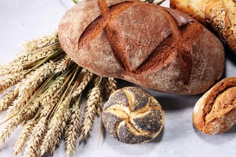 Different kinds of bread and bread rolls on board from above. Kitchen or bake Stock Photos