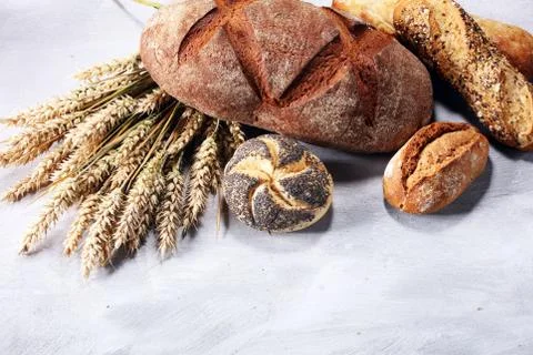 Different kinds of bread and bread rolls on board from above. Kitchen or bake Stock Photos