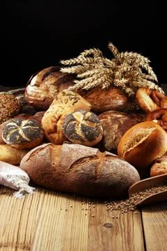 Different kinds of bread and bread rolls on board from above. Kitchen or bake Stock Photos