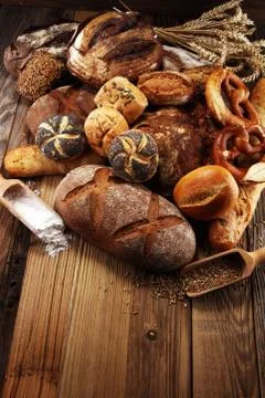 Different kinds of bread and bread rolls on board from above. Kitchen or bake Stock Photos