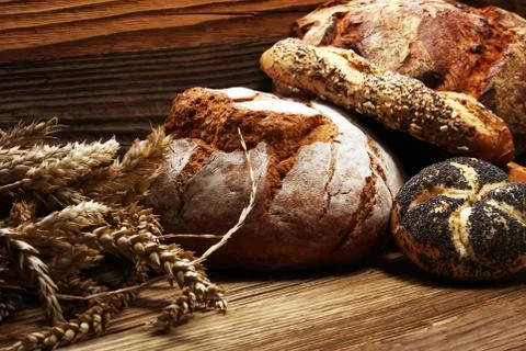 Different kinds of bread and bread rolls on board from above. Kitchen or bake Stock Photos